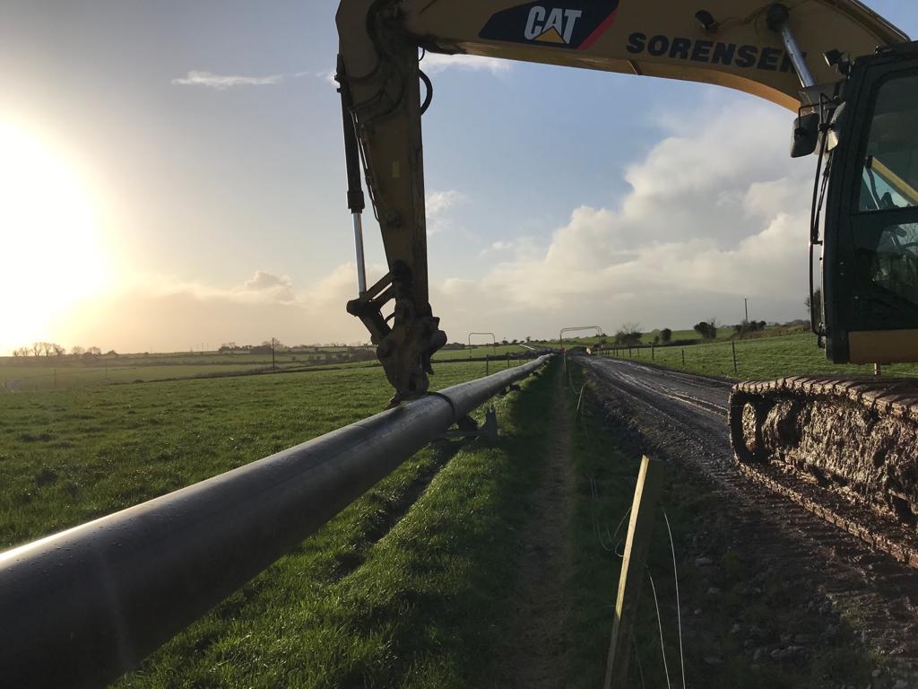 A crane pulling a pipe from the ground