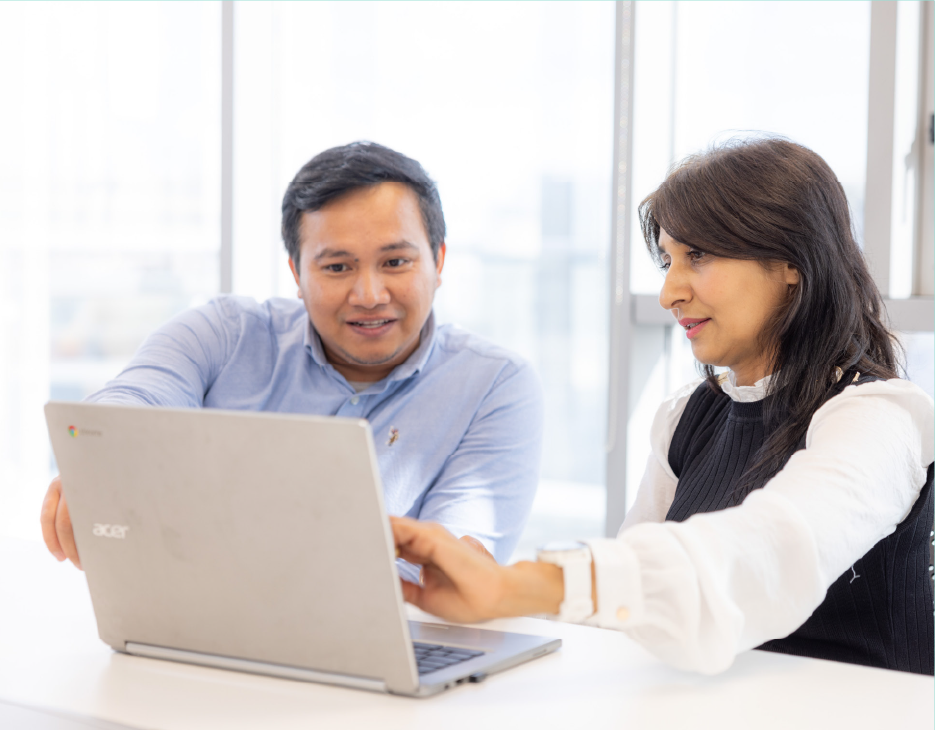 Fear agus bean i dtimpeallacht oifige ag athbhreithniú ábhar ar ríomhaire glúine. Níl an t-ábhar infheicthe.