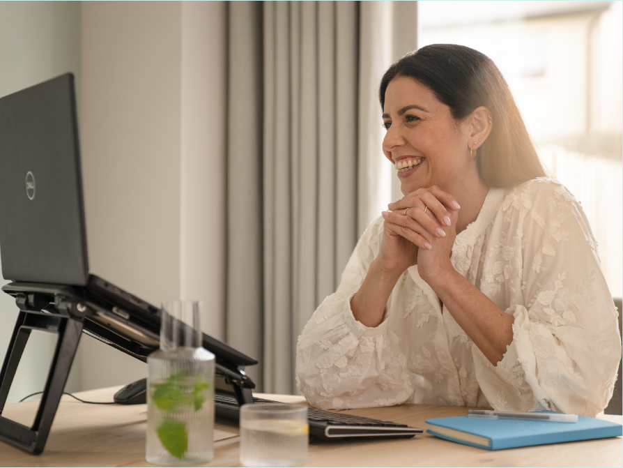 Bean i dtimpeallacht obair ón mbaile i bhfísghlao ar ríomhaire glúine.