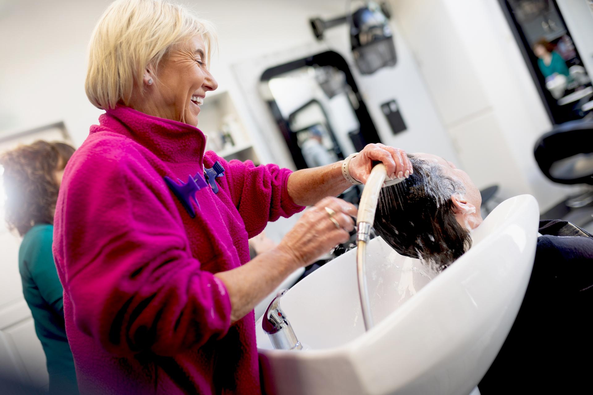 A hairdresser washing a customer's hair