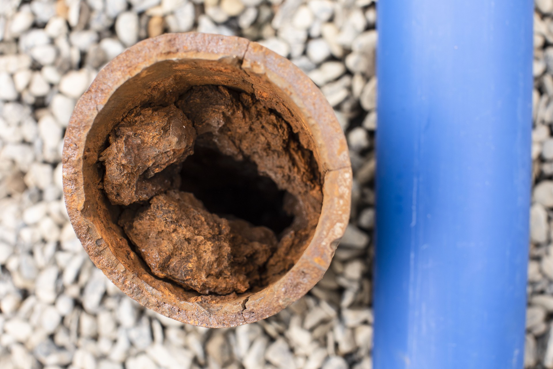 A new clean pipe next to an old damaged and rusty pipe