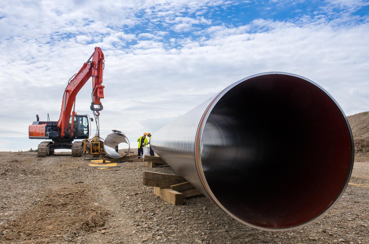 A large pipe and a crane in a large field
