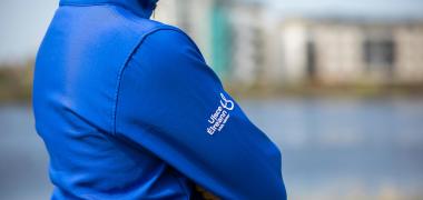 A side view of a man wearing a blue Uisce Éireann jacket