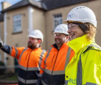 3 UÉ workers smiling at an LRP site