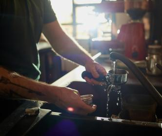 Barista cleaning coffee equipment