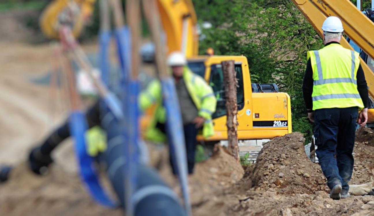 A construction site with two men walking towards each other 